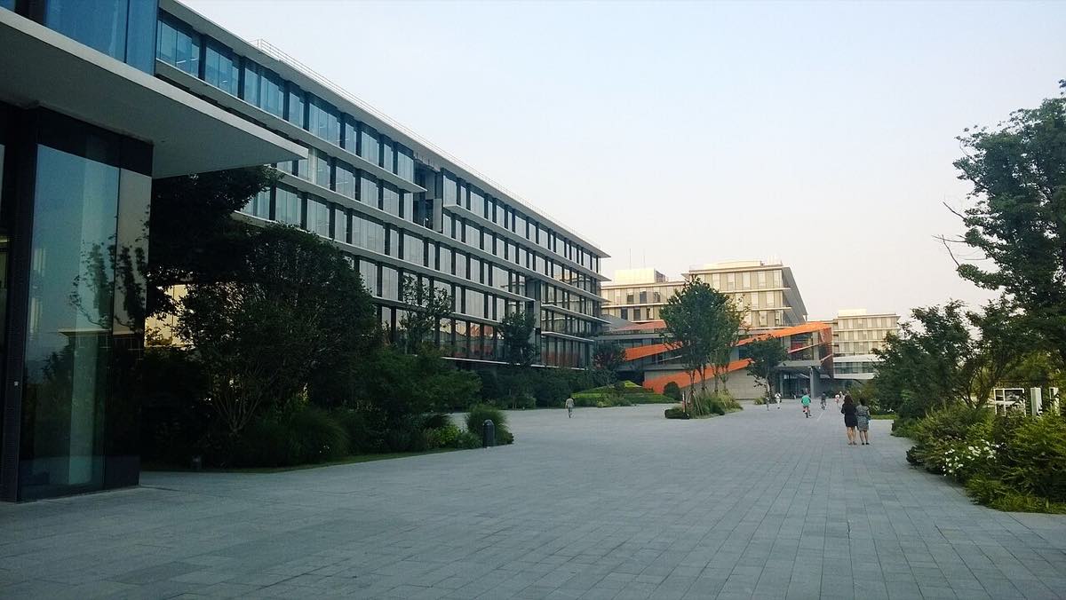 Prédio de escritórios do campus da Alibaba em Hangzhou, visto de fora, com jardins na frente.