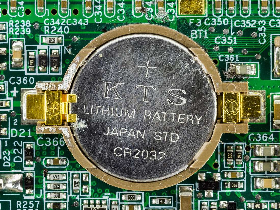 Bateria de lítio CR-2032 encaixada no soquete de uma placa-mãe de notebook