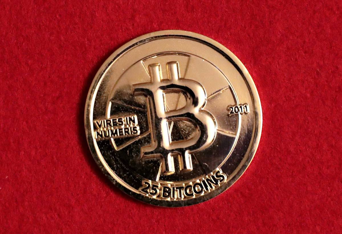 Moeda física dourada Casascius representando 25 bitcoins, vista de perto
