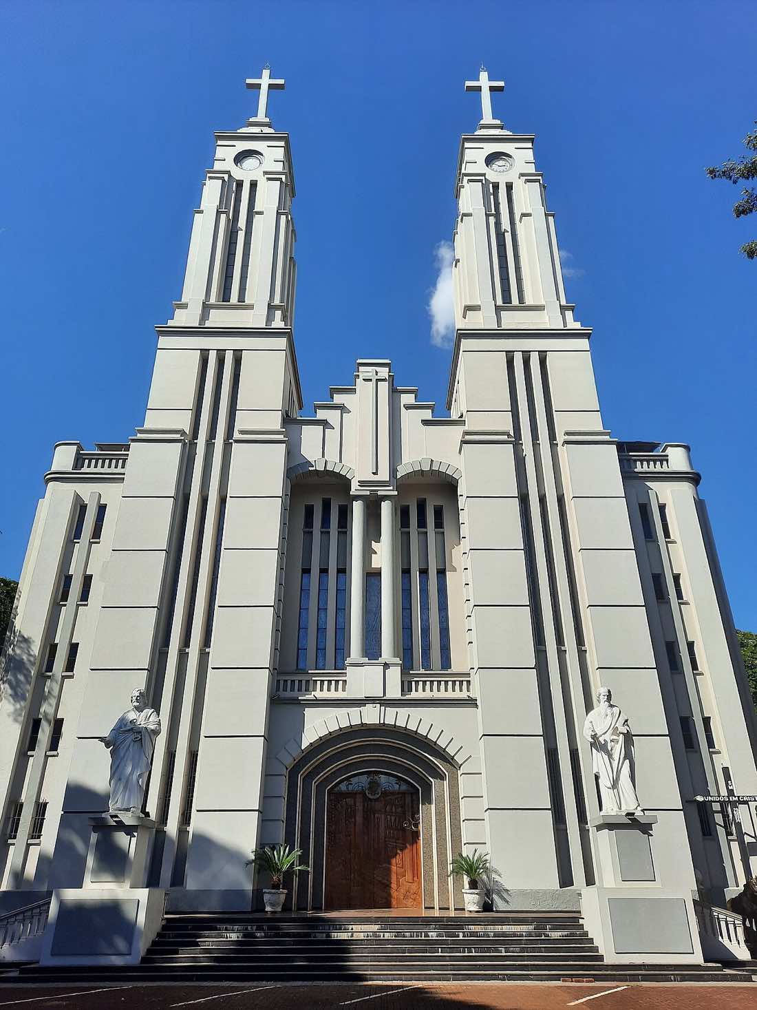 Fachada da Catedral São José, em Campo Mourão, no Paraná, com duas torres brancas e escadaria sob céu azul