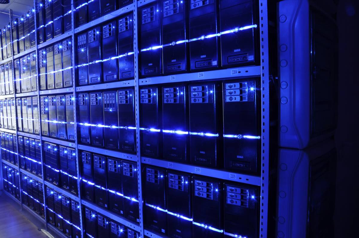 Corredor de um data center com fileiras de racks de servidores iluminados