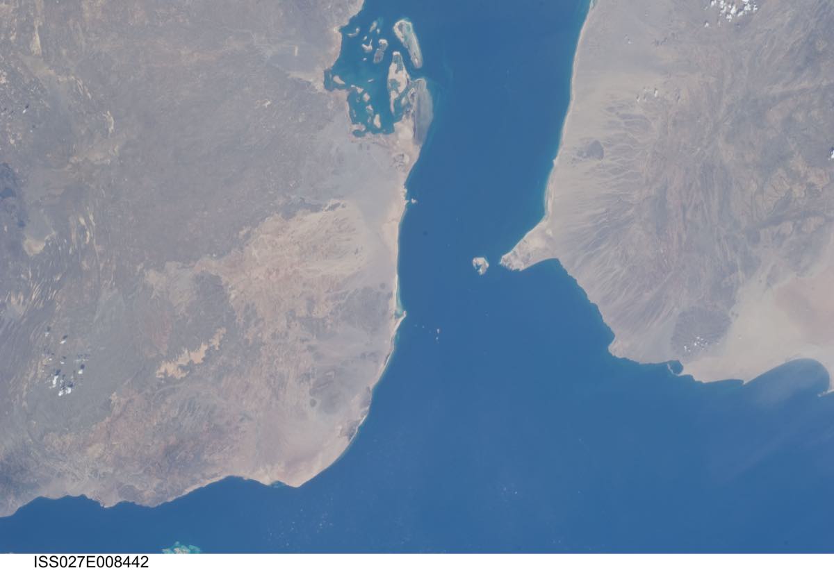 Fotografia tirada da Estação Espacial Internacional mostrando o estreito de Bab el-Mandeb, com a costa árida de Djibuti à esquerda, o Iêmen à direita e o mar azul-escuro entre os dois