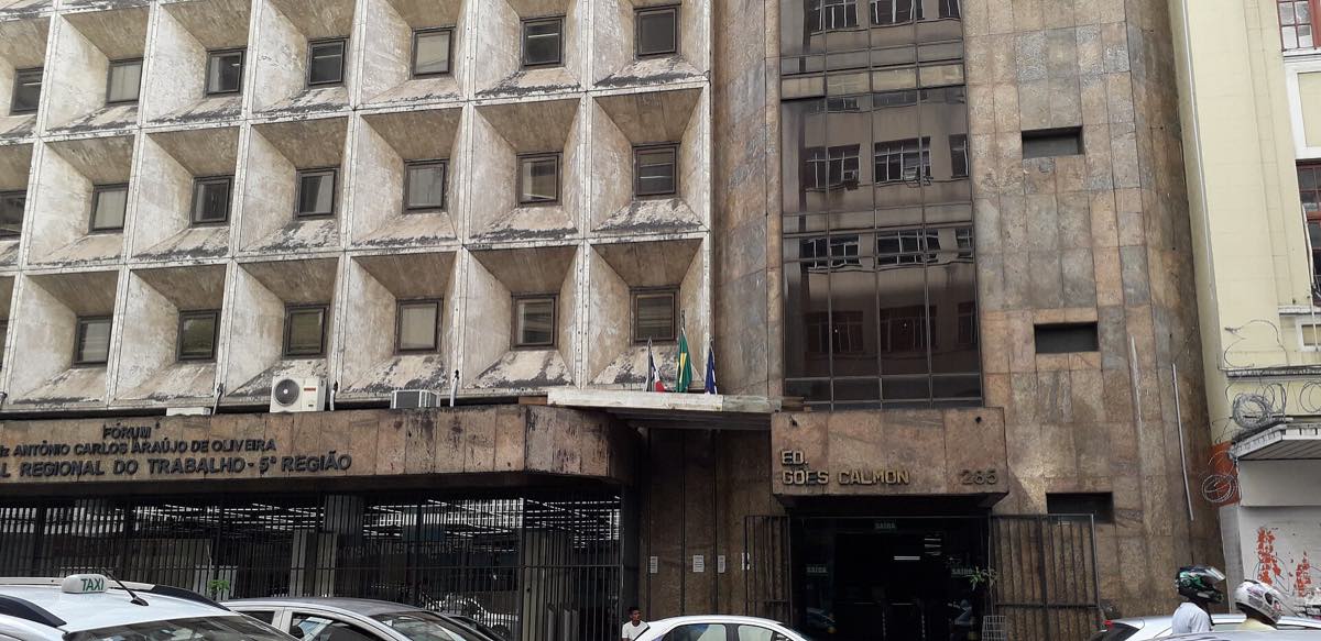 Edifício alto e comprido de concreto no bairro do Comércio, em Salvador, visto da rua em dia nublado