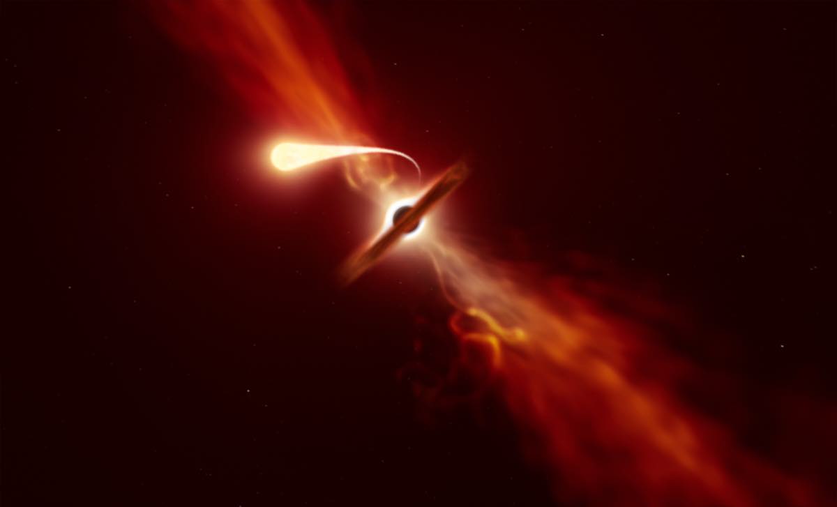 Concepção artística de uma estrela sendo esticada e despedaçada em filamentos brilhantes pela gravidade de um buraco negro supermassivo, com um disco luminoso ao redor
