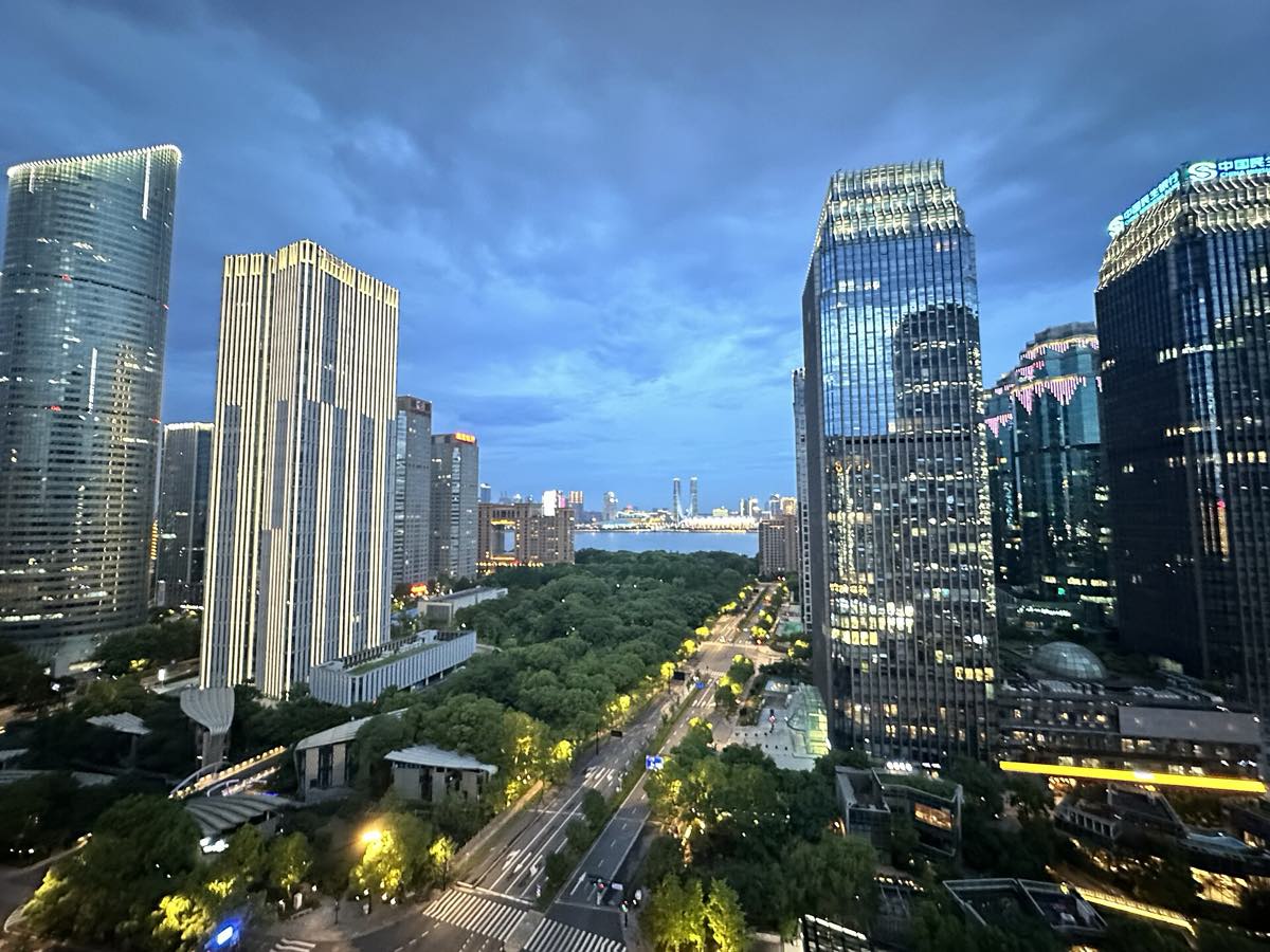 Arranha-céus iluminados do distrito financeiro Qianjiang New City, em Hangzhou, vistos do alto ao anoitecer