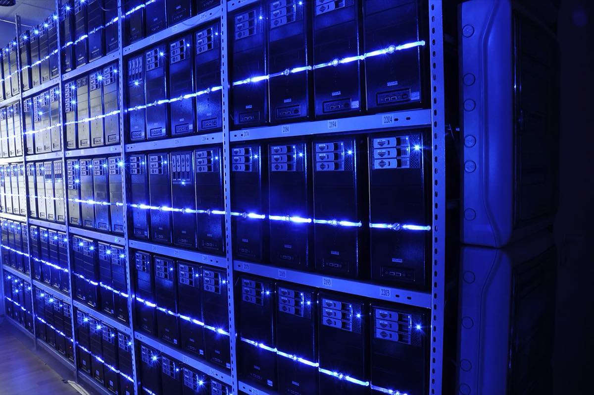 Corredor de um data center com fileiras de servidores iluminados