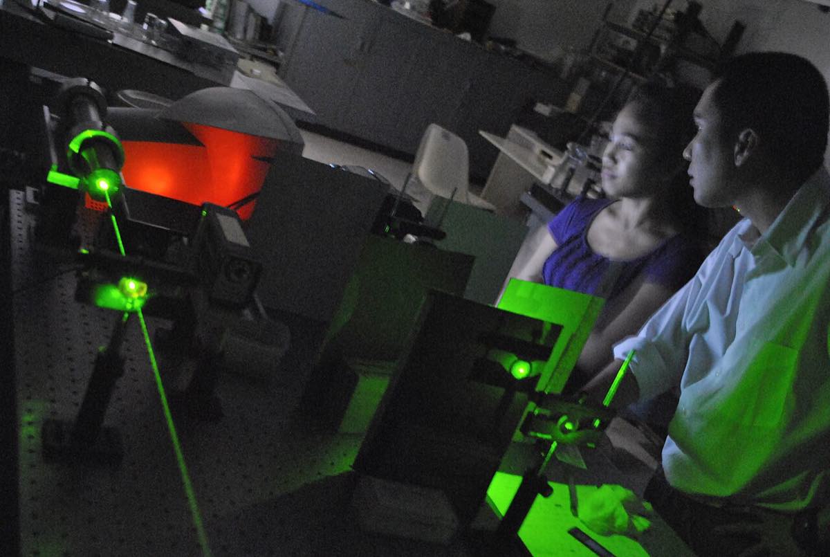 Experimento com feixe de laser sobre uma mesa óptica em laboratório de fotônica