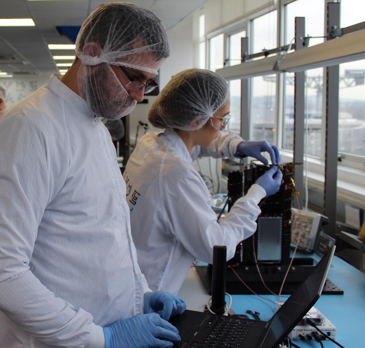 Engenheiros montam uma plataforma de pequeno satélite (3U) em sala limpa