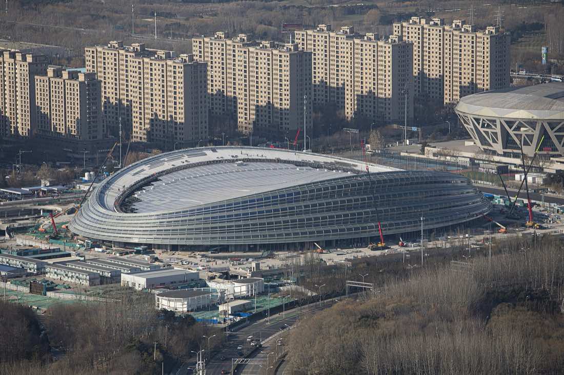 Vista externa do National Speed Skating Oval, em Pequim, com sua fachada de faixas curvas de vidro