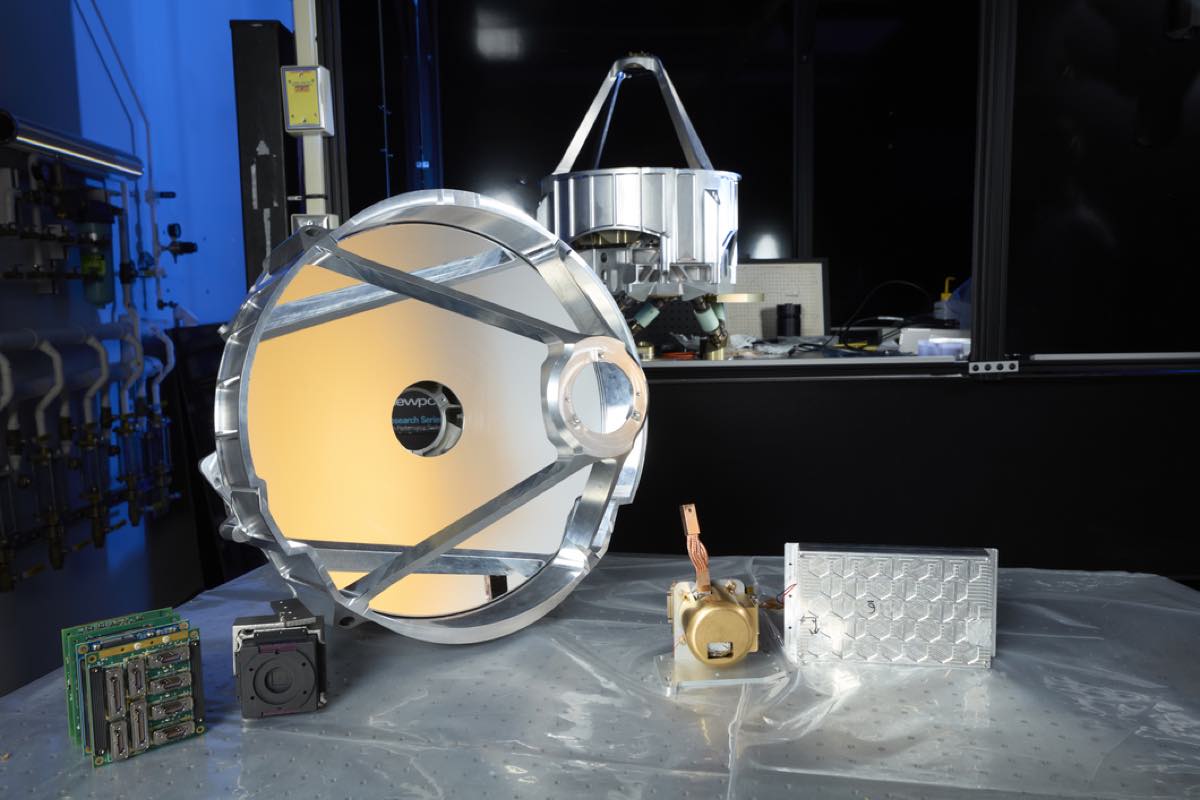 Peça de hardware da missão Pandora sobre bancada de laboratório, com estrutura metálica e cabos
