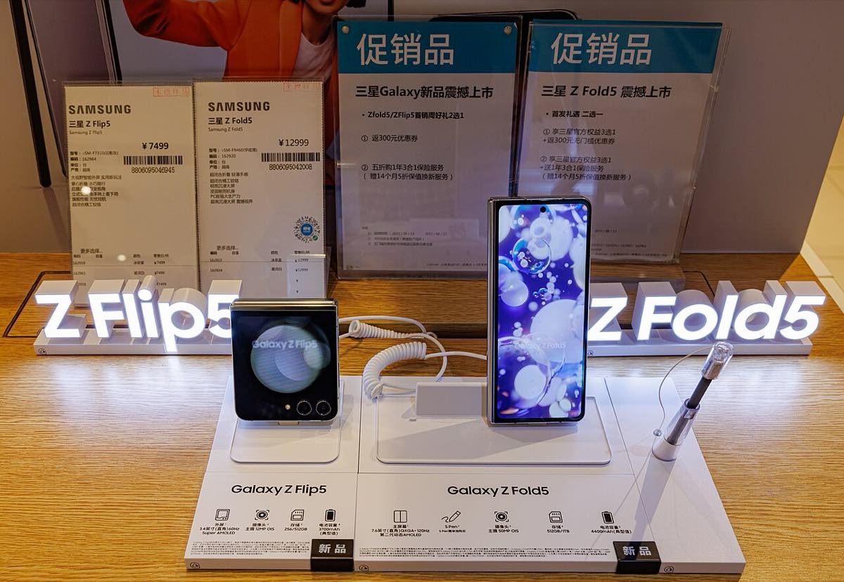 Galaxy Z Flip 5 e Galaxy Z Fold 5 abertos lado a lado sobre uma superfície clara