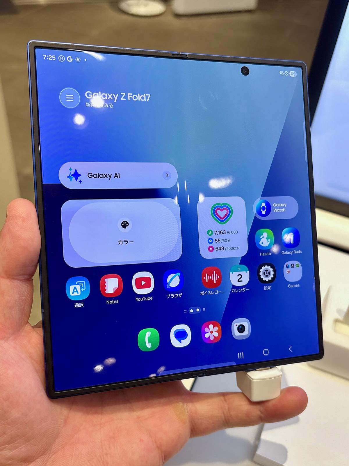 O Samsung Galaxy Z Fold7 aberto, segurado na mão, mostrando a ampla tela interna dobrável na página inicial do aparelho.