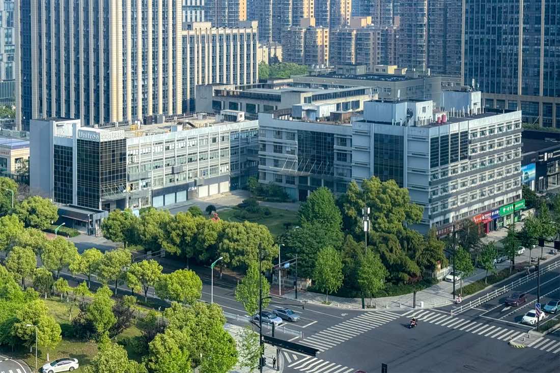 Vista aérea do conjunto de prédios da sede da Unitree em Hangzhou, cercado por avenidas arborizadas