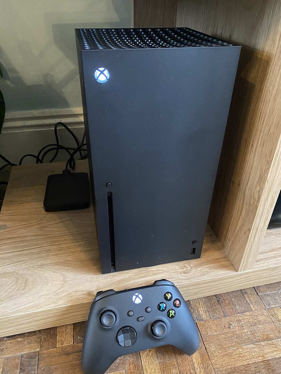 Console Xbox Series X em pé sobre uma superfície escura