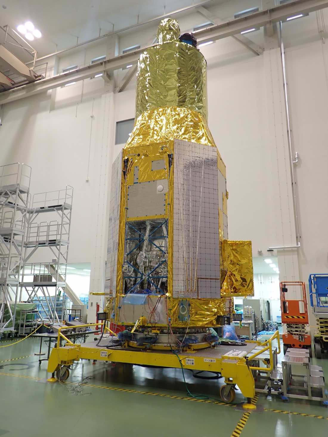 O satélite XRISM em uma sala limpa do Centro Espacial de Tsukuba, no Japão, em maio de 2022, com painéis dourados e o compartimento aberto do instrumento Resolve na parte inferior